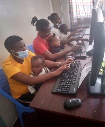Teens at computers with babies Teens at computers with babies
